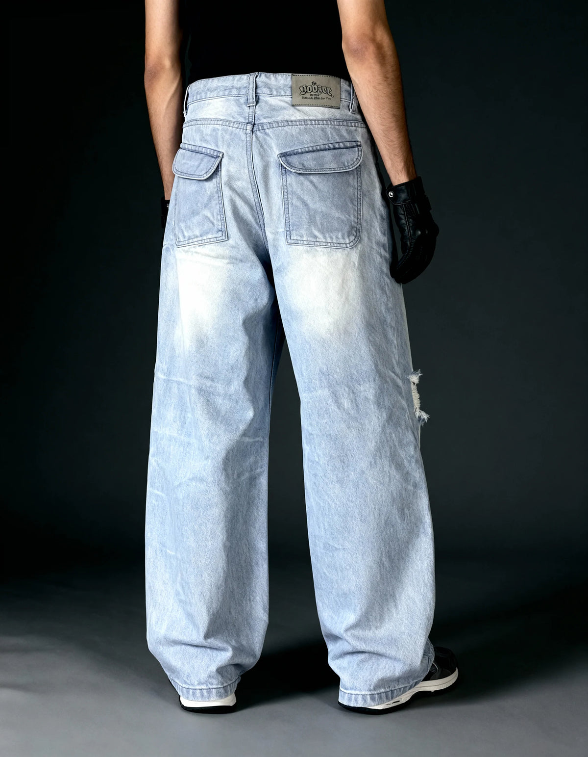 Light wash baggy jeans with wide legs, front pockets, belt loops, small knee rip.
