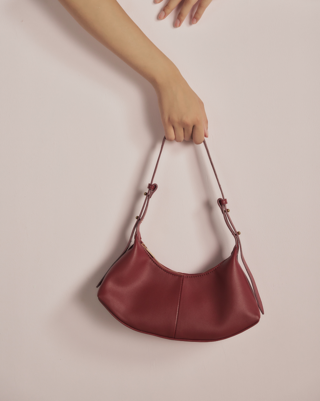 Red leather hobo bag close-up with two short handles and gathered top