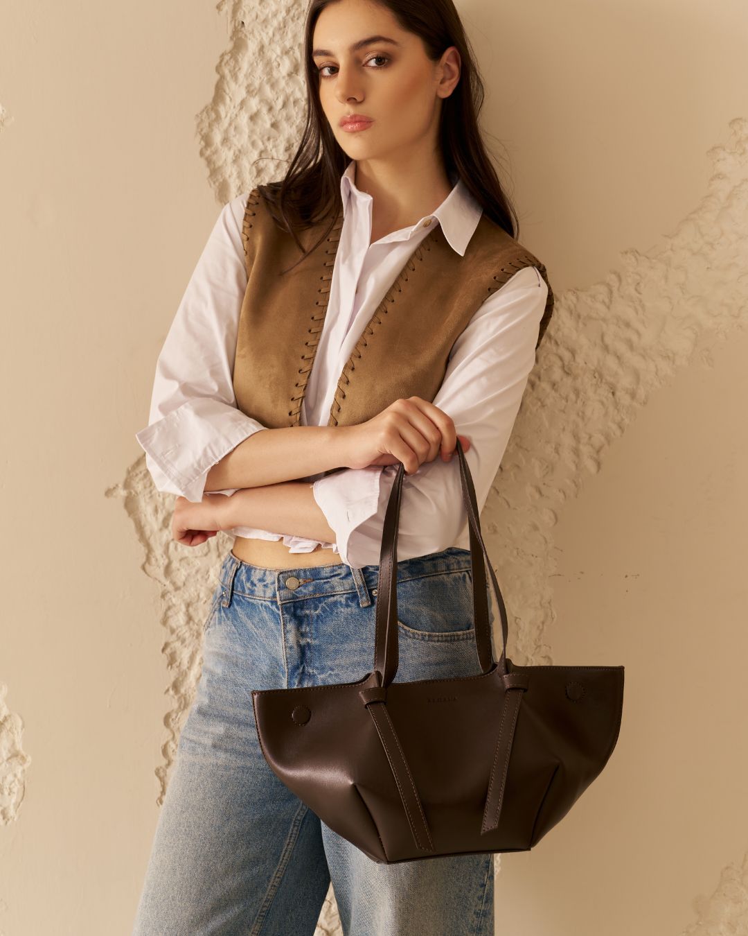 Dark brown tote bag with top handles and long adjustable shoulder strap