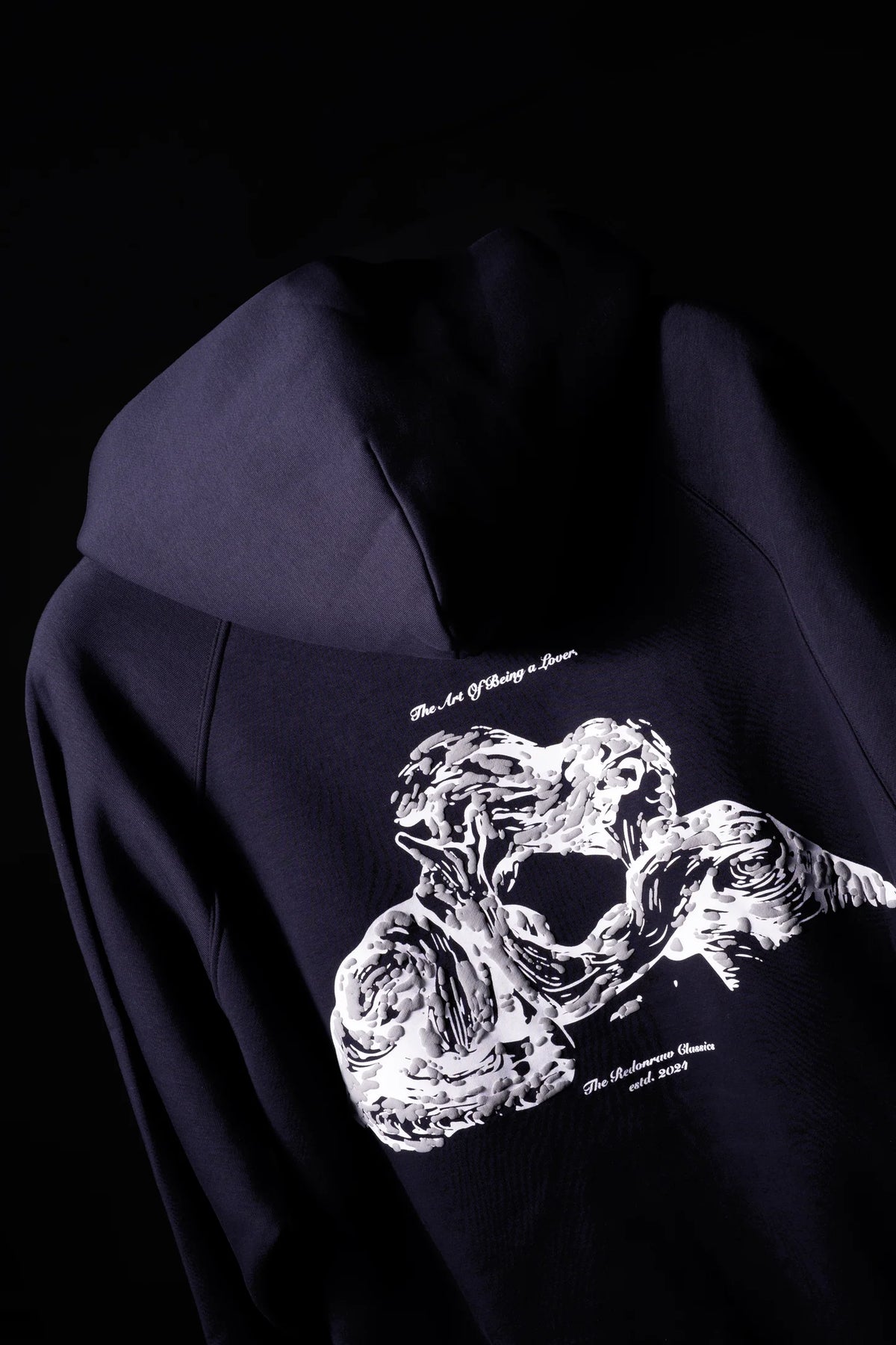 Dark navy hoodie with large white graphic print, hood and sleeves visible