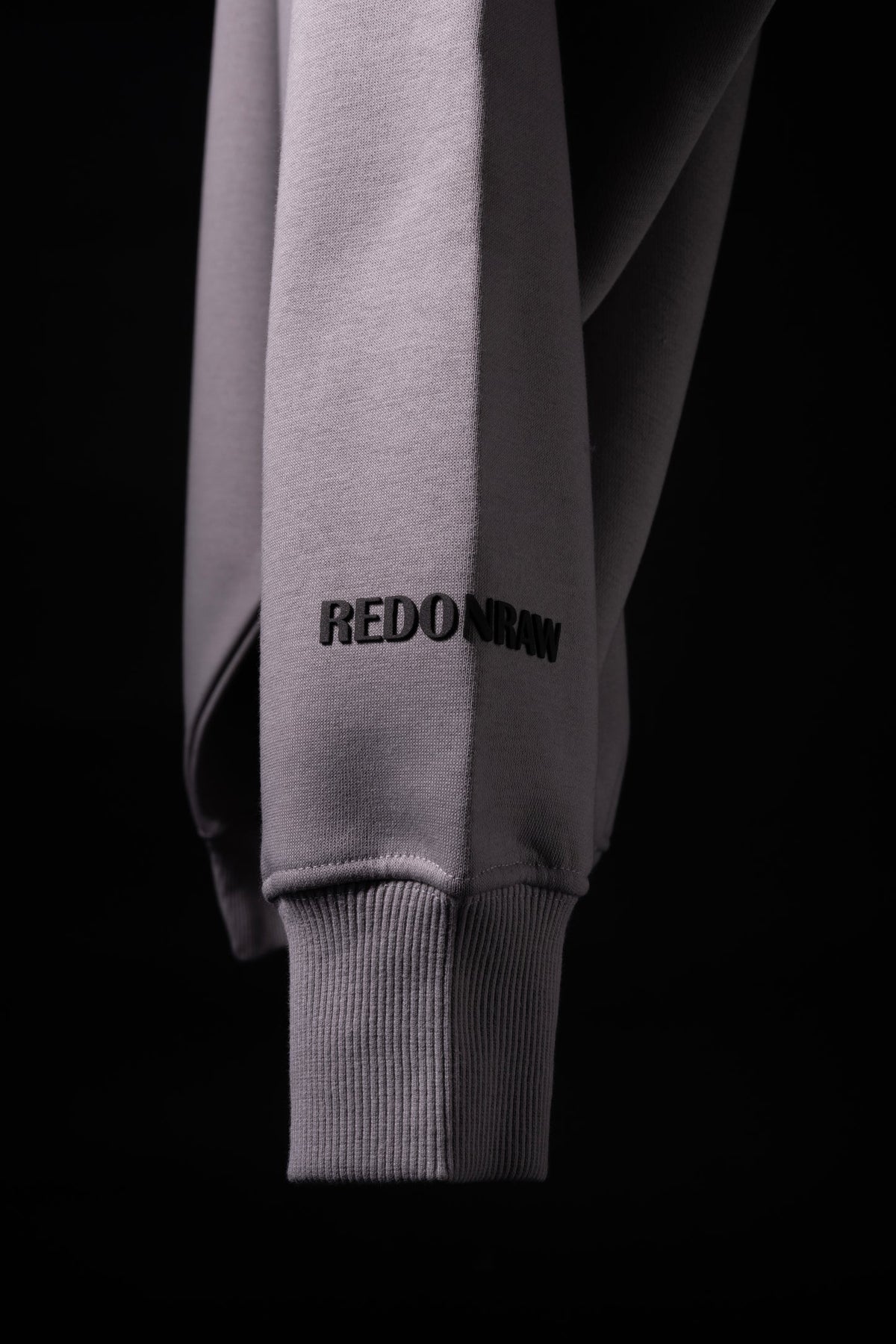 Light purple hoodie sleeve with REDONDRAW text and ribbed cuff