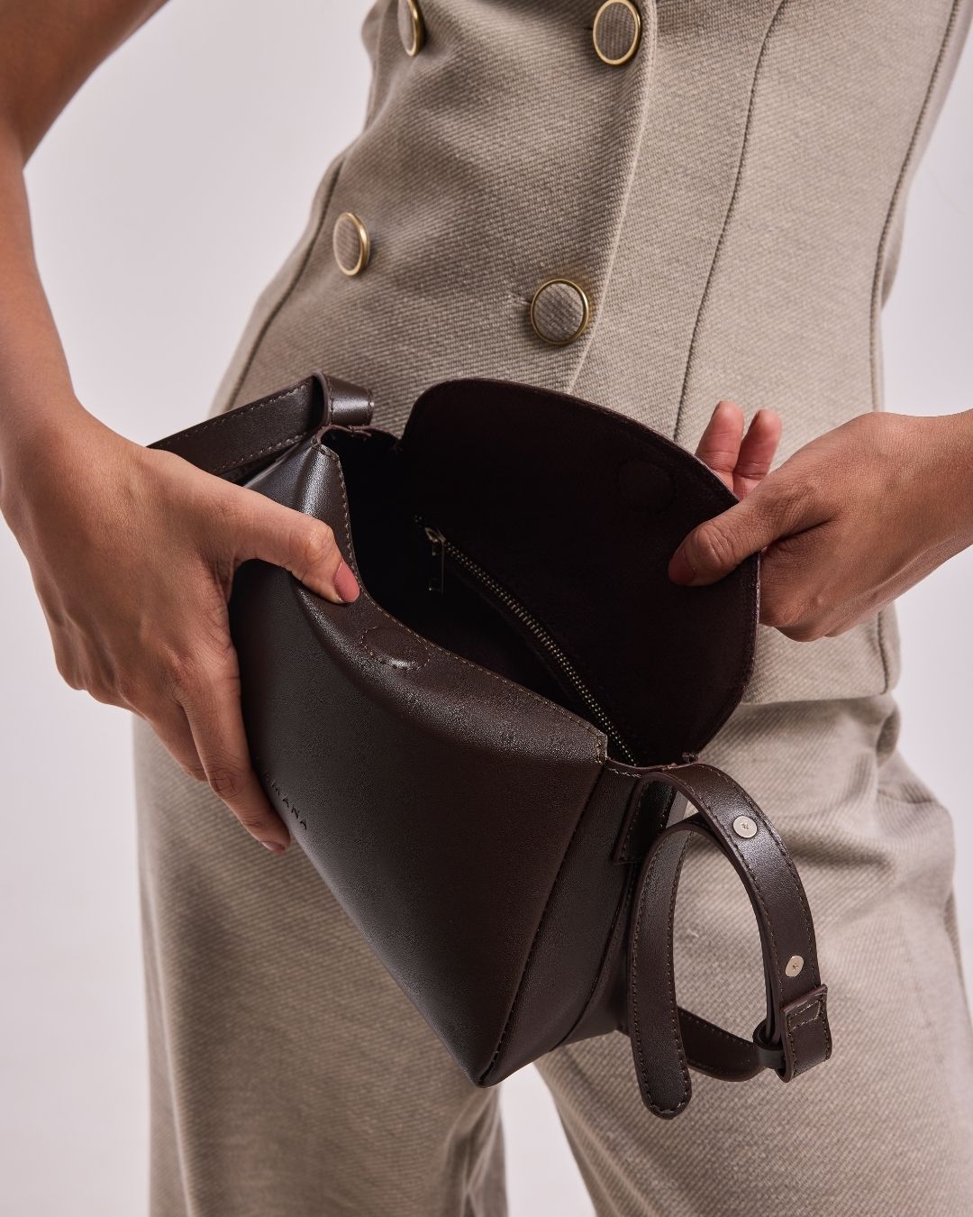 Small dark brown leather hobo bag open to show inner zip pocket