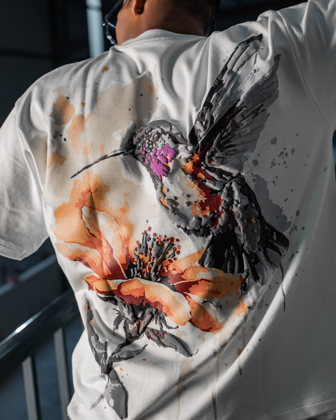 White crewneck T-shirt with close-up orange, purple, and black splatter back print