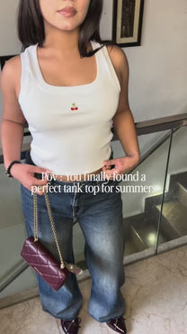 White sleeveless tank top with cherry logo at center, scoop neck