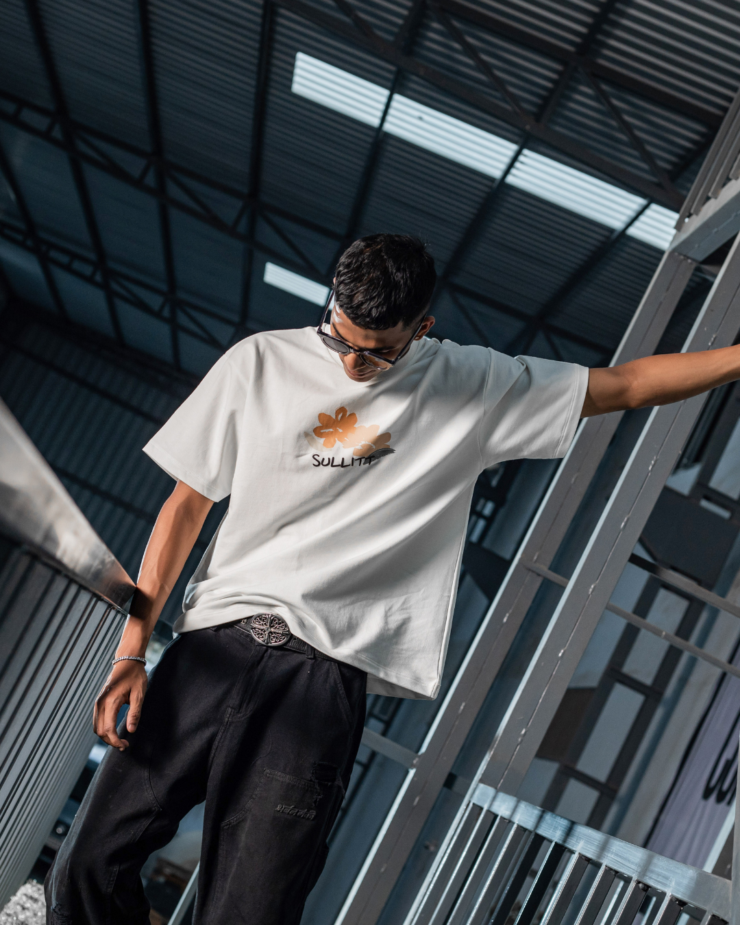 White crewneck graphic T-shirt with small front SunZeta logo, arm-raised pose