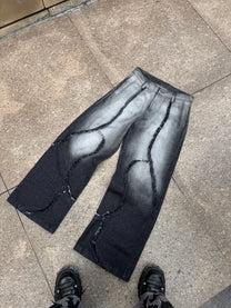 Fade-wash denim jeans laid flat, wide legs with dark stitched side panels