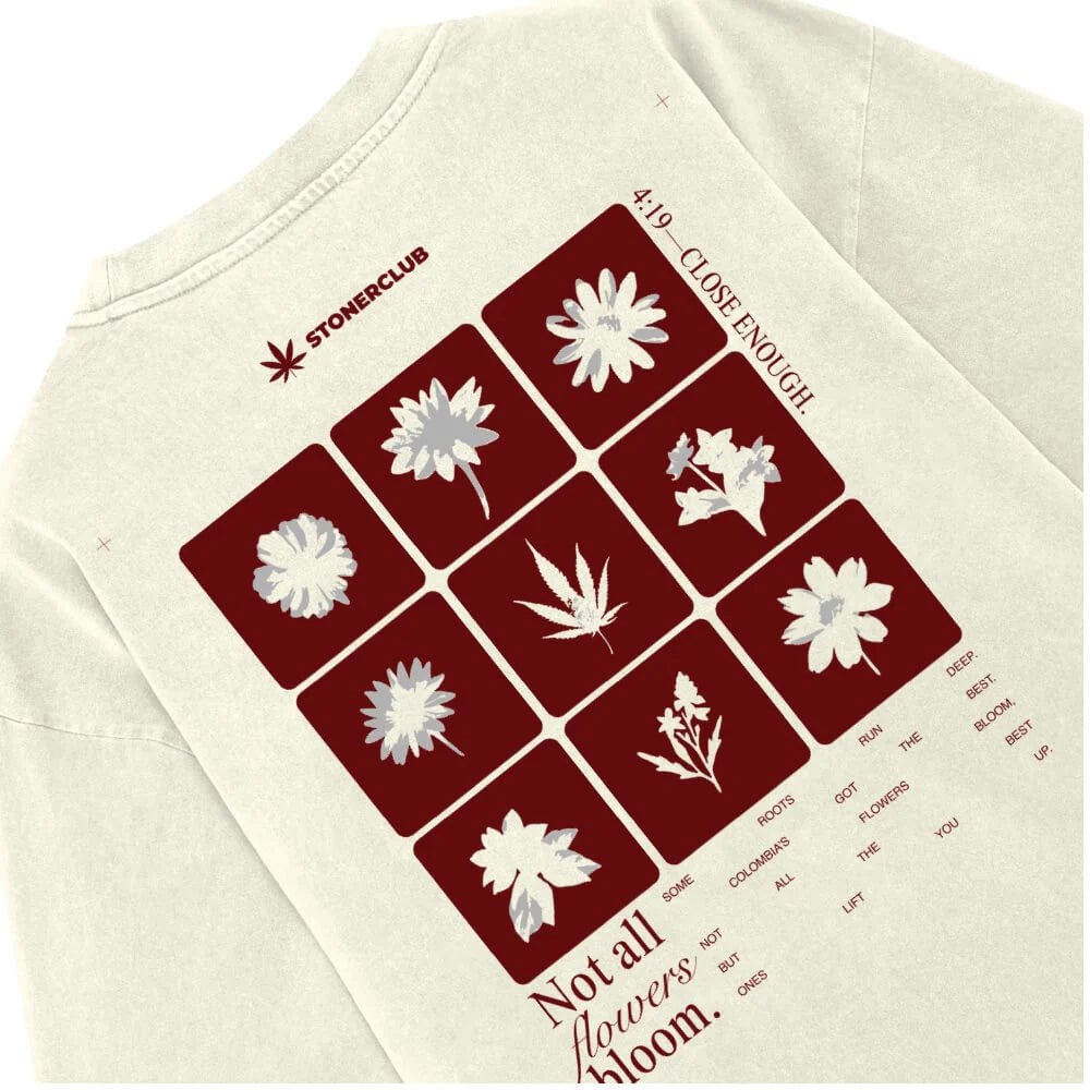 Off-white T-shirt back showing maroon floral grid print and 'Not all flowers bloom.'