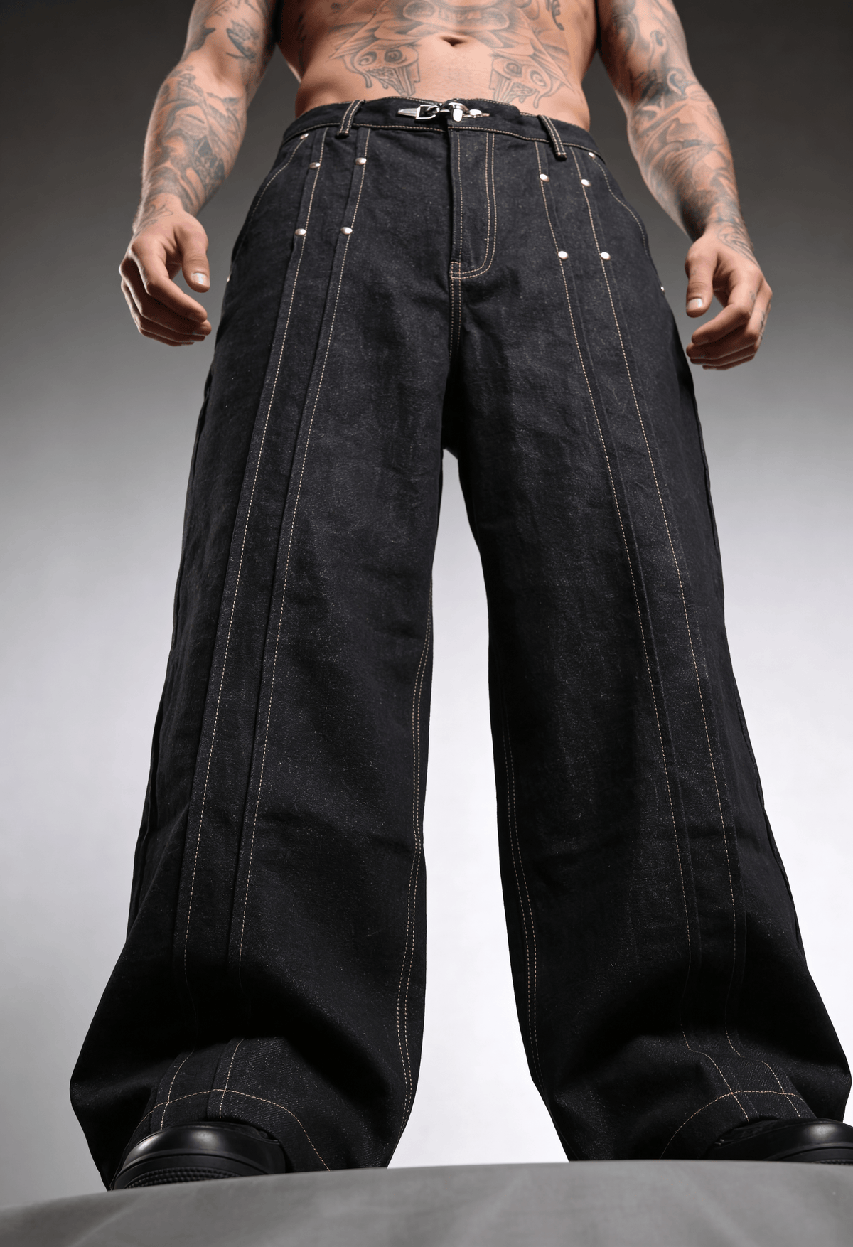 Black raw denim wide-leg jeans front view with metal button and pocket detailing