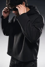 Dark cropped hoodie with hood, long sleeves, and front kangaroo pocket; wearer adjusts hood
