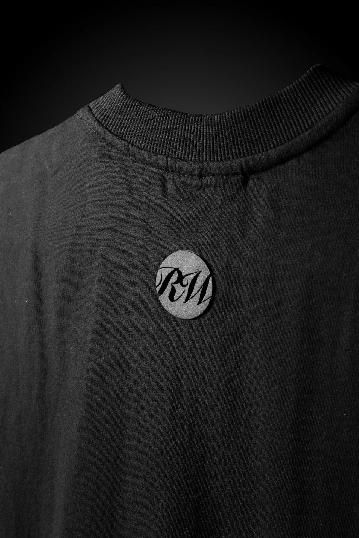 Black crewneck T-shirt with round chest emblem