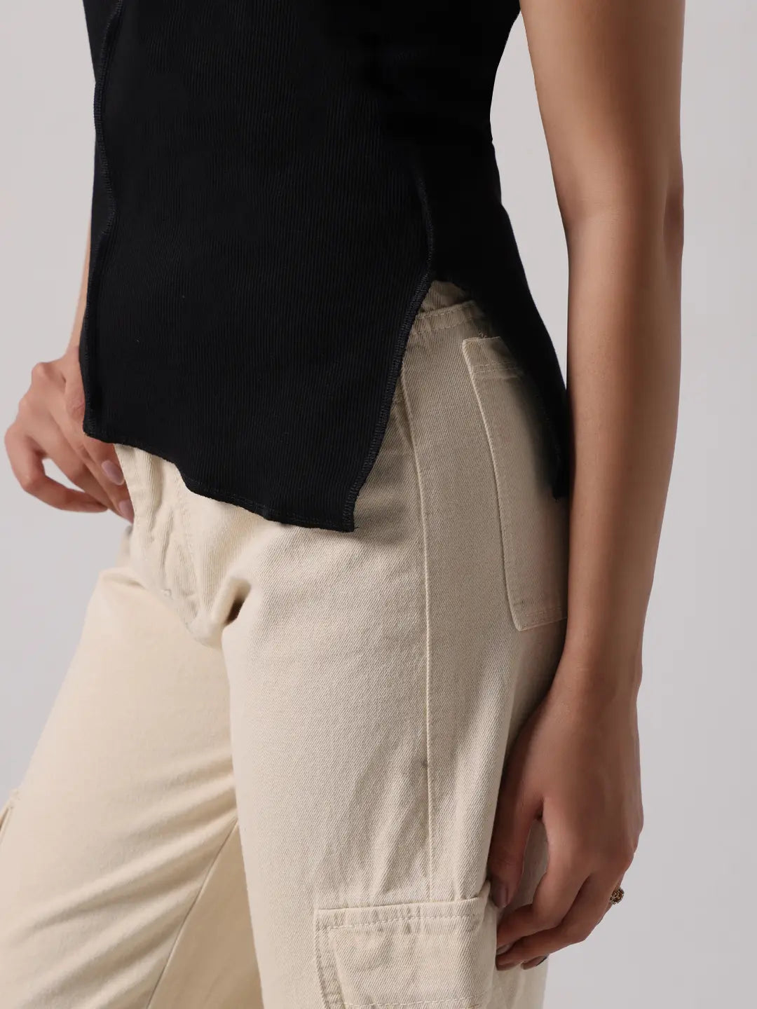 Black top with curved hem slit and front exposed stitching detail