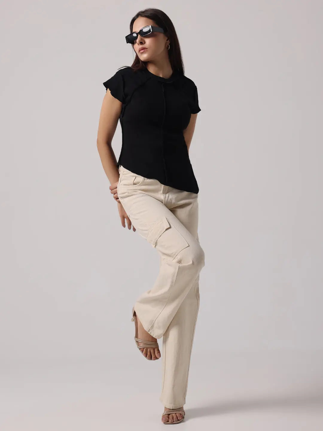 Black cap-sleeve top with round neckline and exposed center stitching; side slit hem