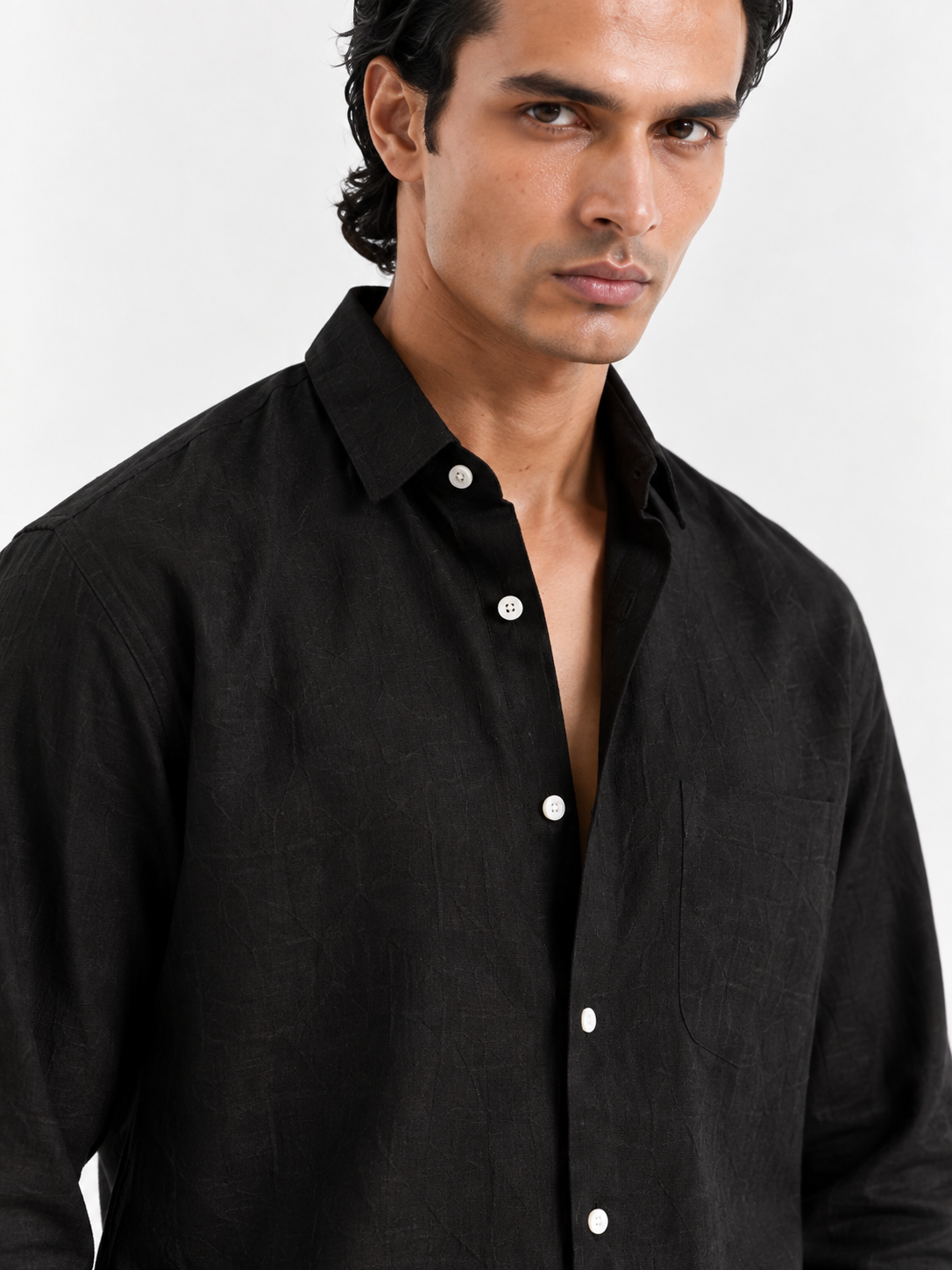 Black linen shirt close-up with pointed collar and white button front.
