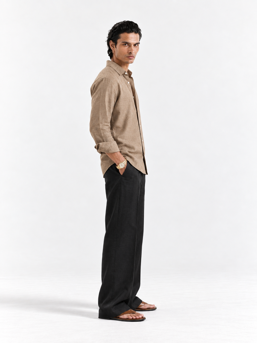 Tan linen button-up shirt, long sleeves and buttons; side view with black pants