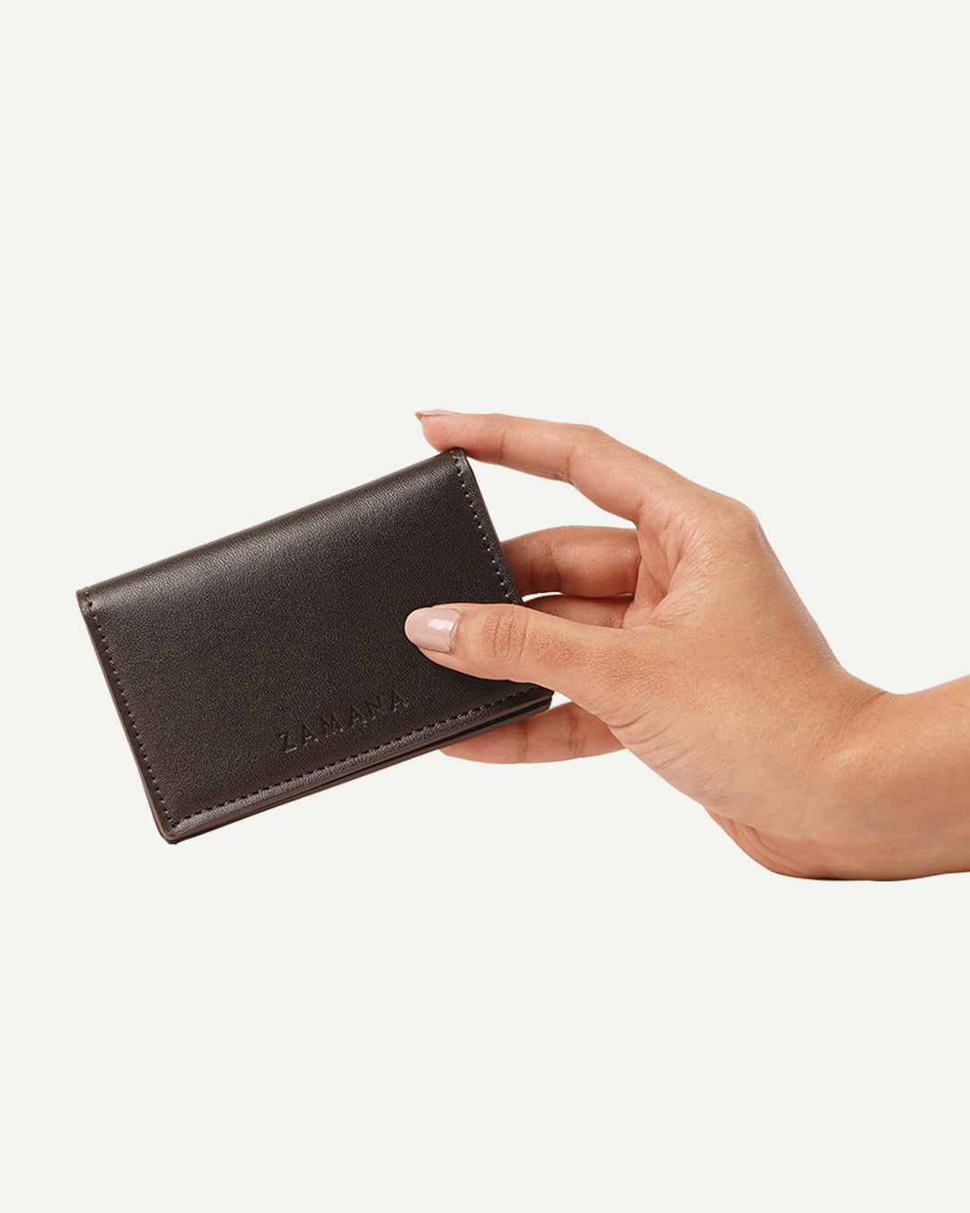 Dark brown card holder wallet angled view with hand holding it