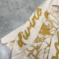 Off-white long-sleeve shirt with gold script-style print along sleeve