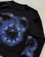 Black long-sleeve shirt with large blue starburst and chain print across chest.