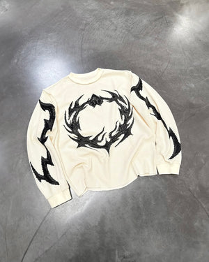 White flame knit long-sleeve top with bold black flame emblem graphic at chest