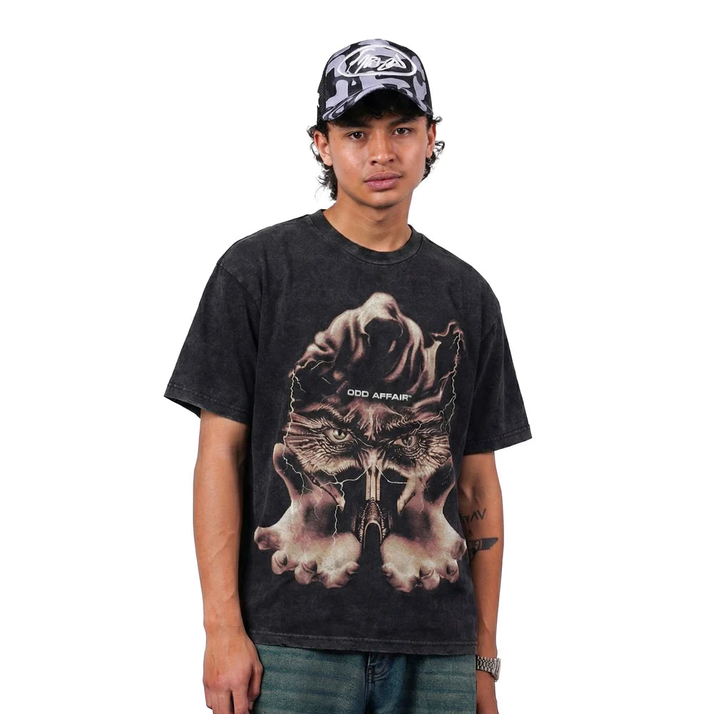 Black T-shirt worn by model, featuring large cat-and-hands front graphic
