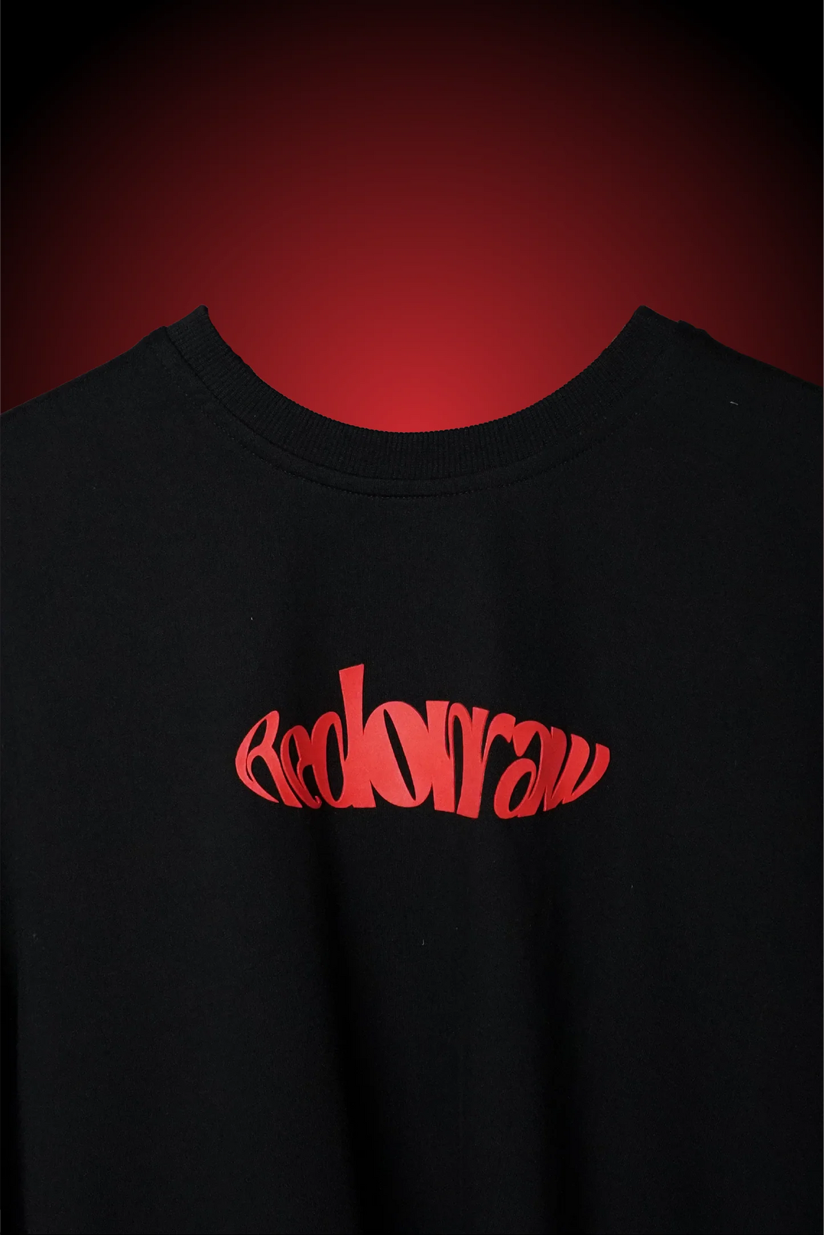 Black crewneck T-shirt with small red logo graphic on the chest.