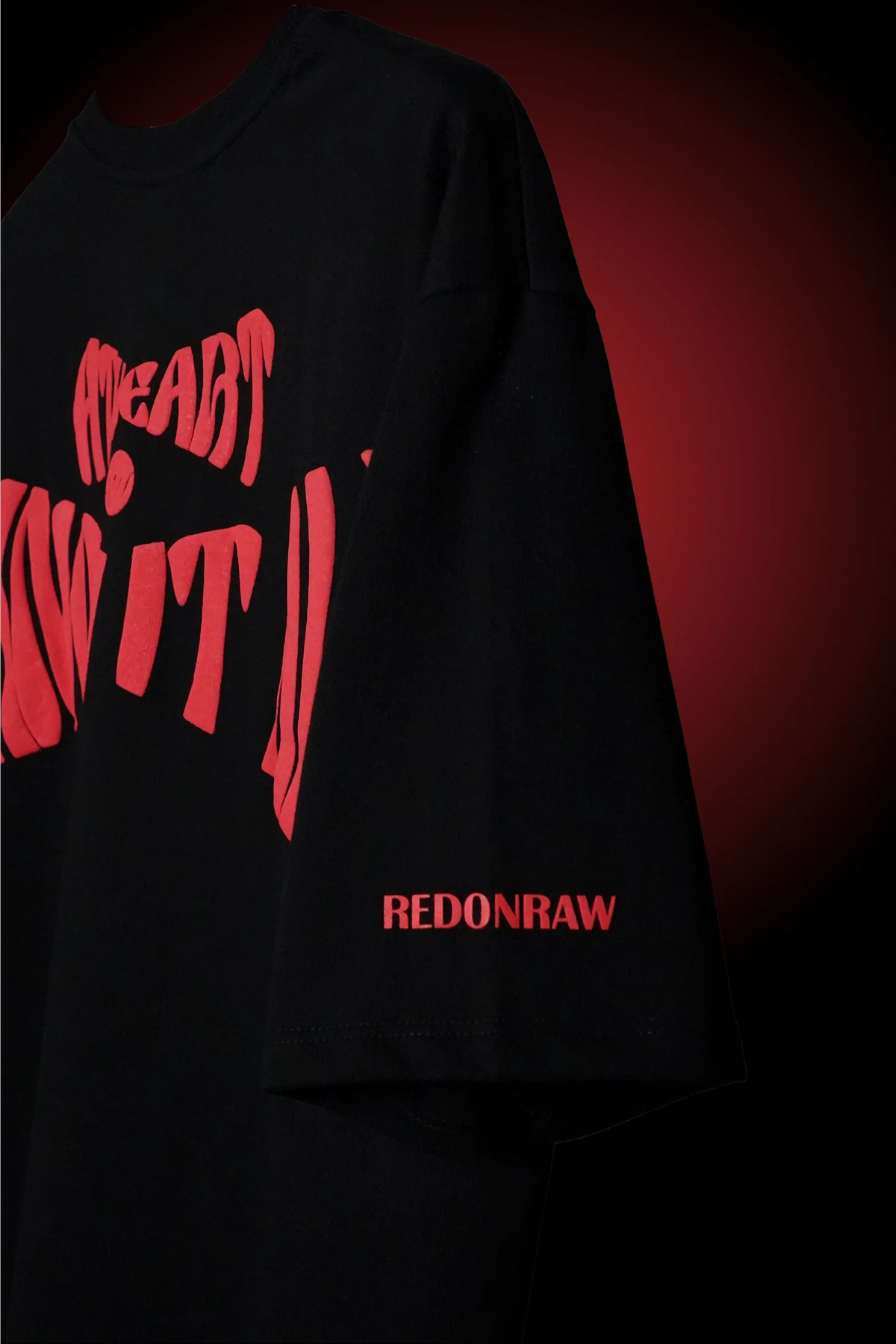 Black T-shirt with red front graphic and red 'REDONRAW' text at the hem.
