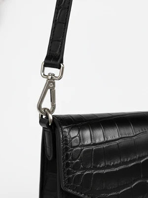 Black croc-embossed leather crossbody bag with metal hardware and adjustable strap.