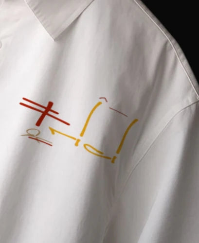 White shirt close-up of multicolor chest graphic and buttoned collar.
