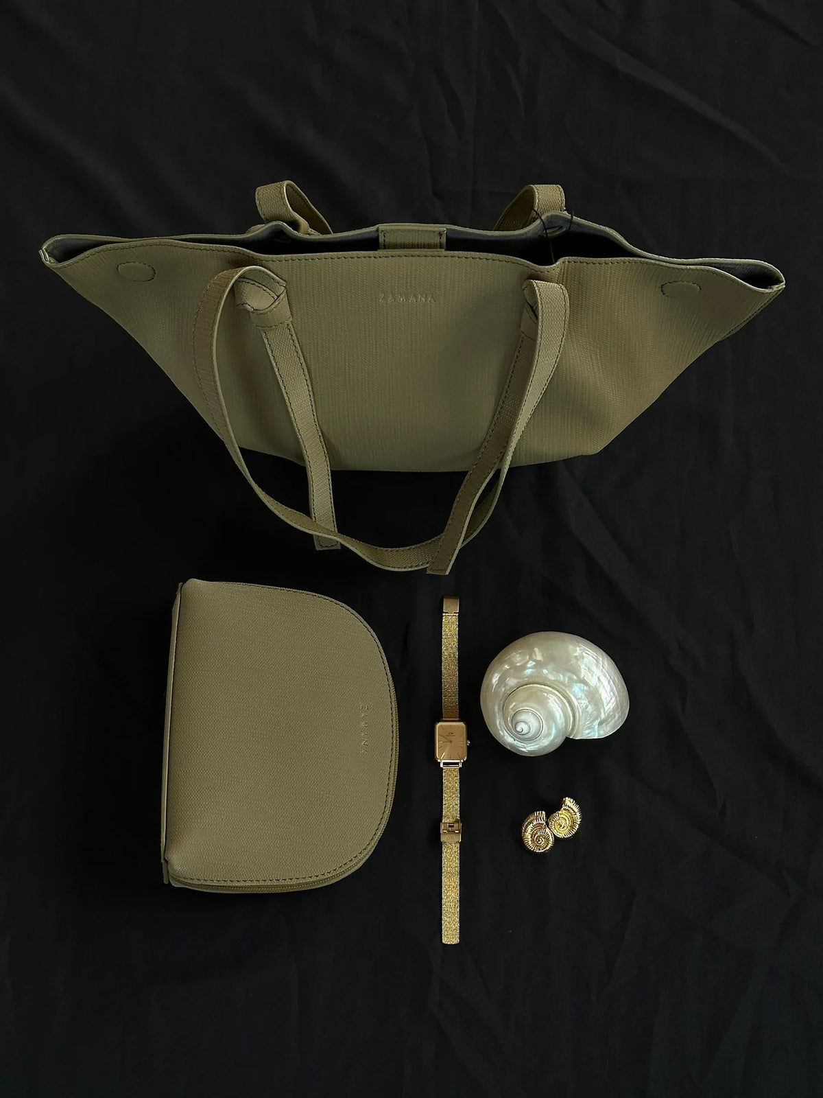 Olive tote bag with matching zip pouch and zipper accessories, flat lay view