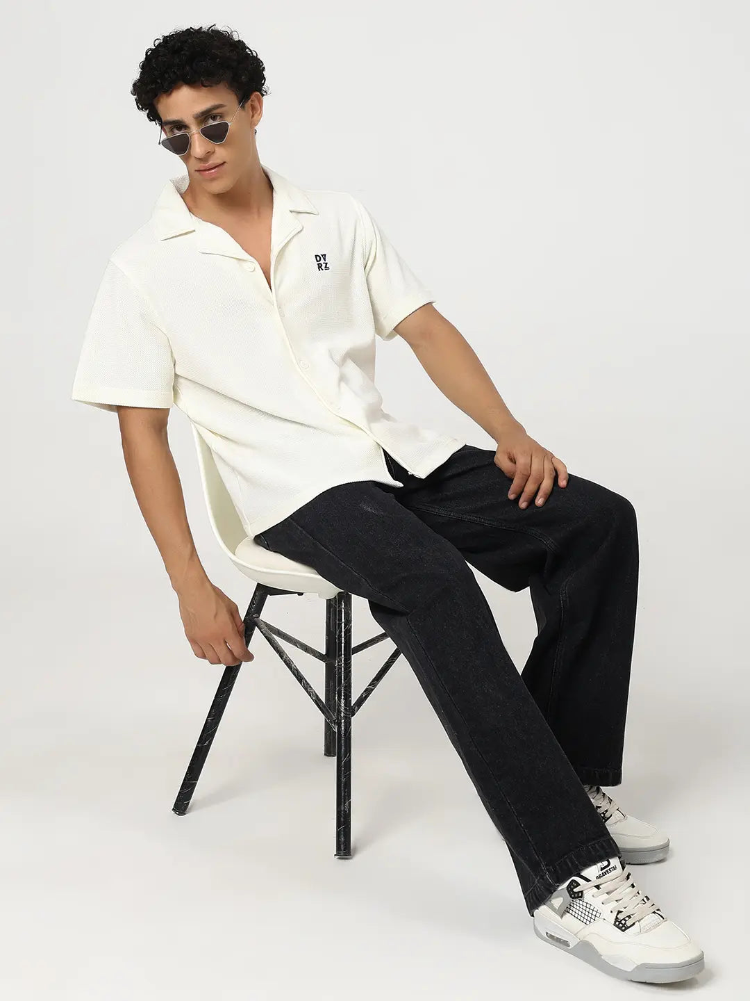 Ivory textured bowling shirt worn with black pants; short-sleeve button-front