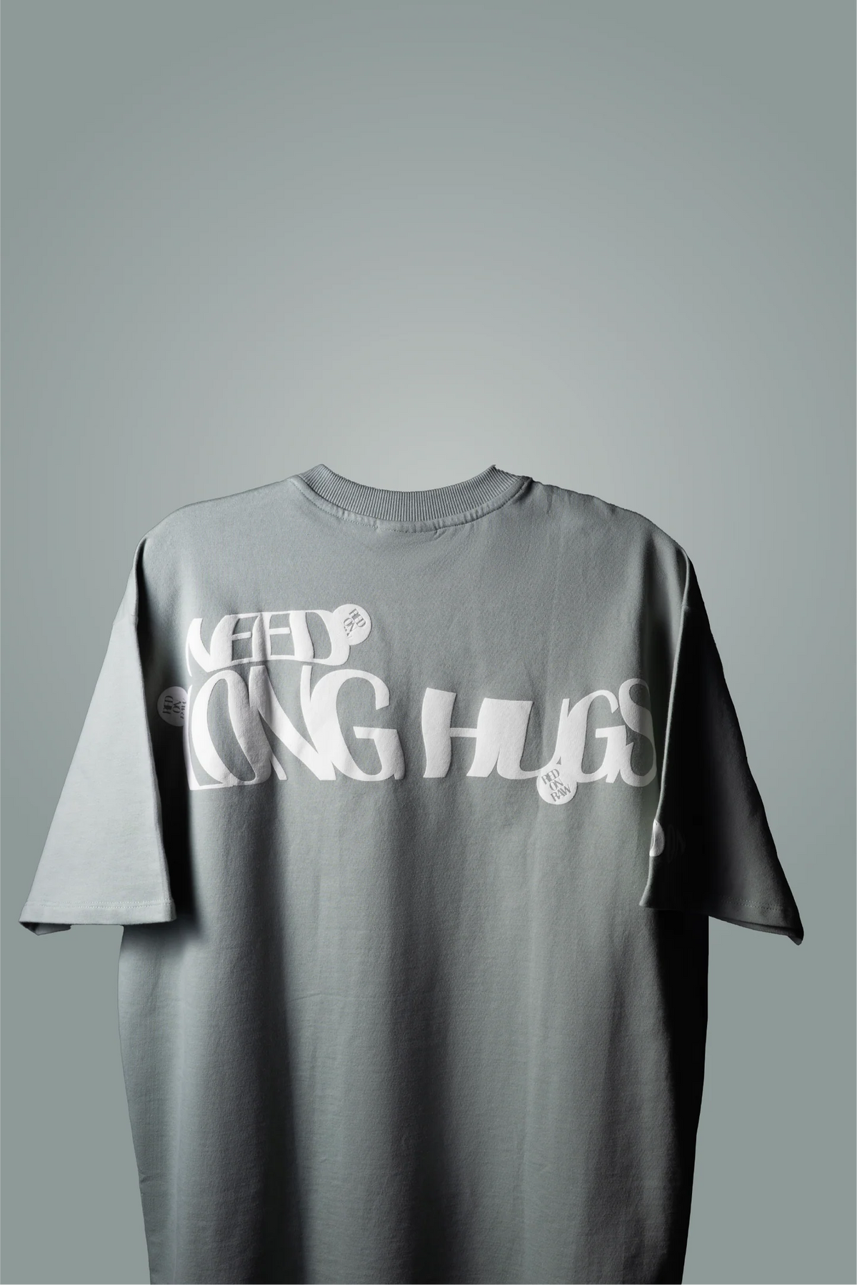 Mint green crew-neck T-shirt with large white 'LONG HUGS' graphic on back
