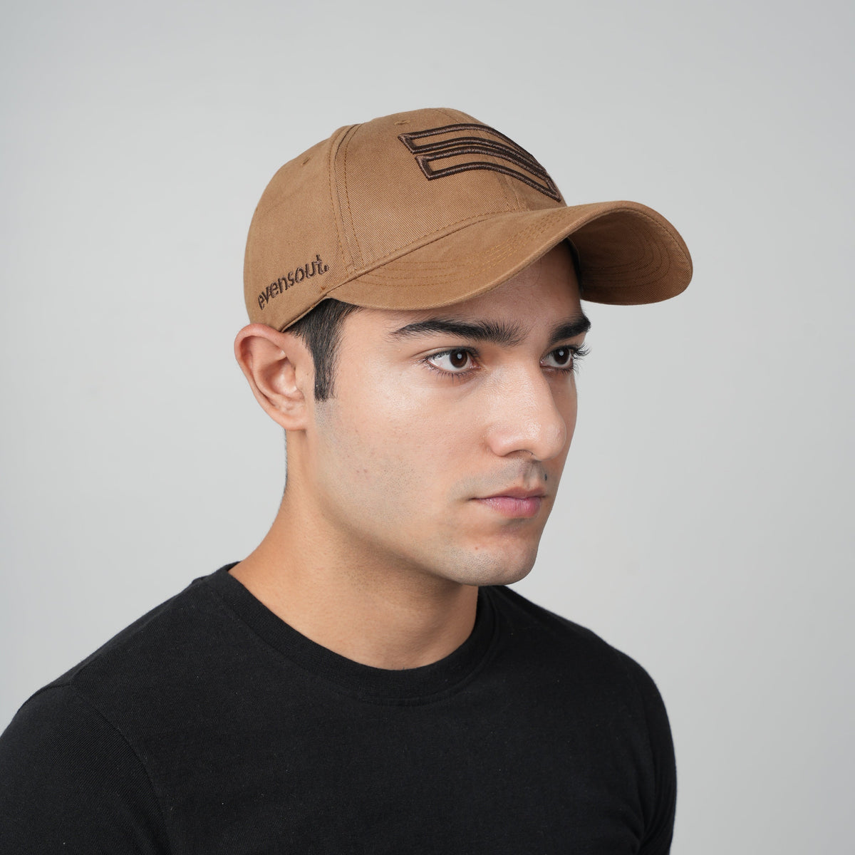 Mocha brown baseball cap viewed from side, stitched logo on crown, curved brim