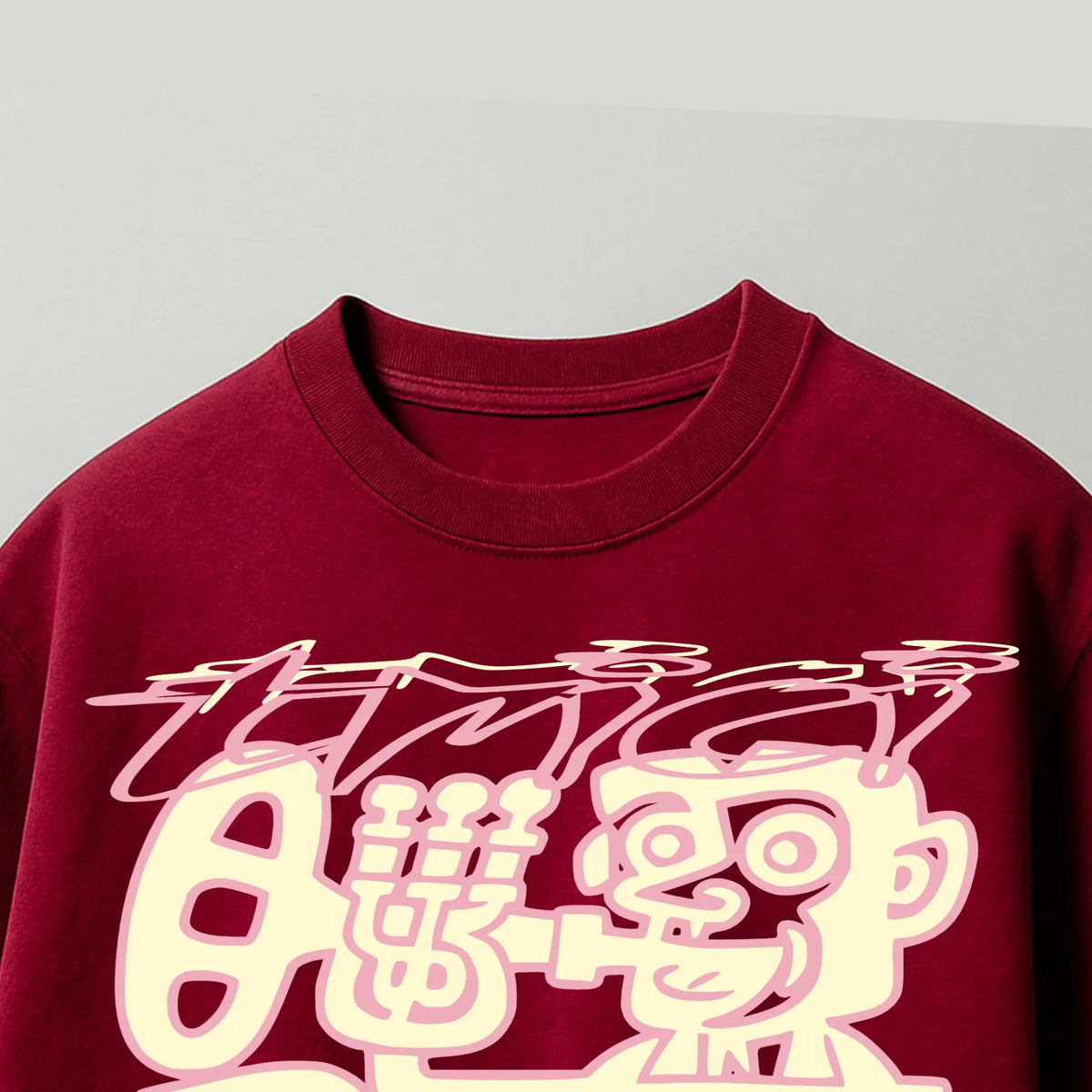 Burgundy T-shirt close-up with white cartoon characters and bold line art