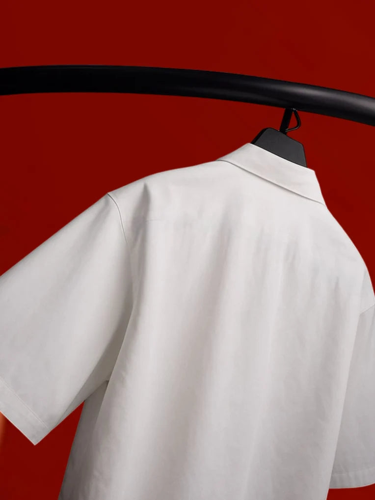 White boxy short-sleeve shirt shoulder close-up with folded collar on hanger