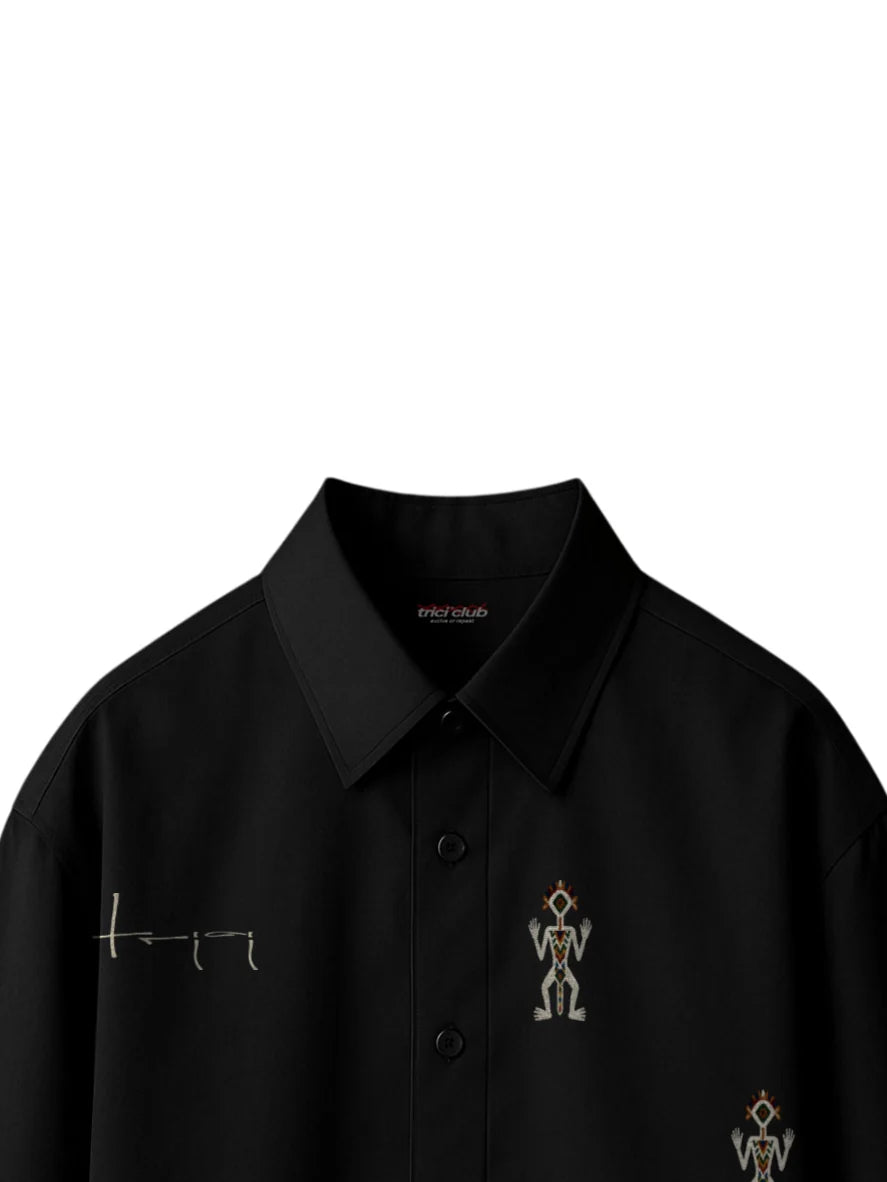 Black boxy fit button-up shirt collar with small embroidered figure on chest