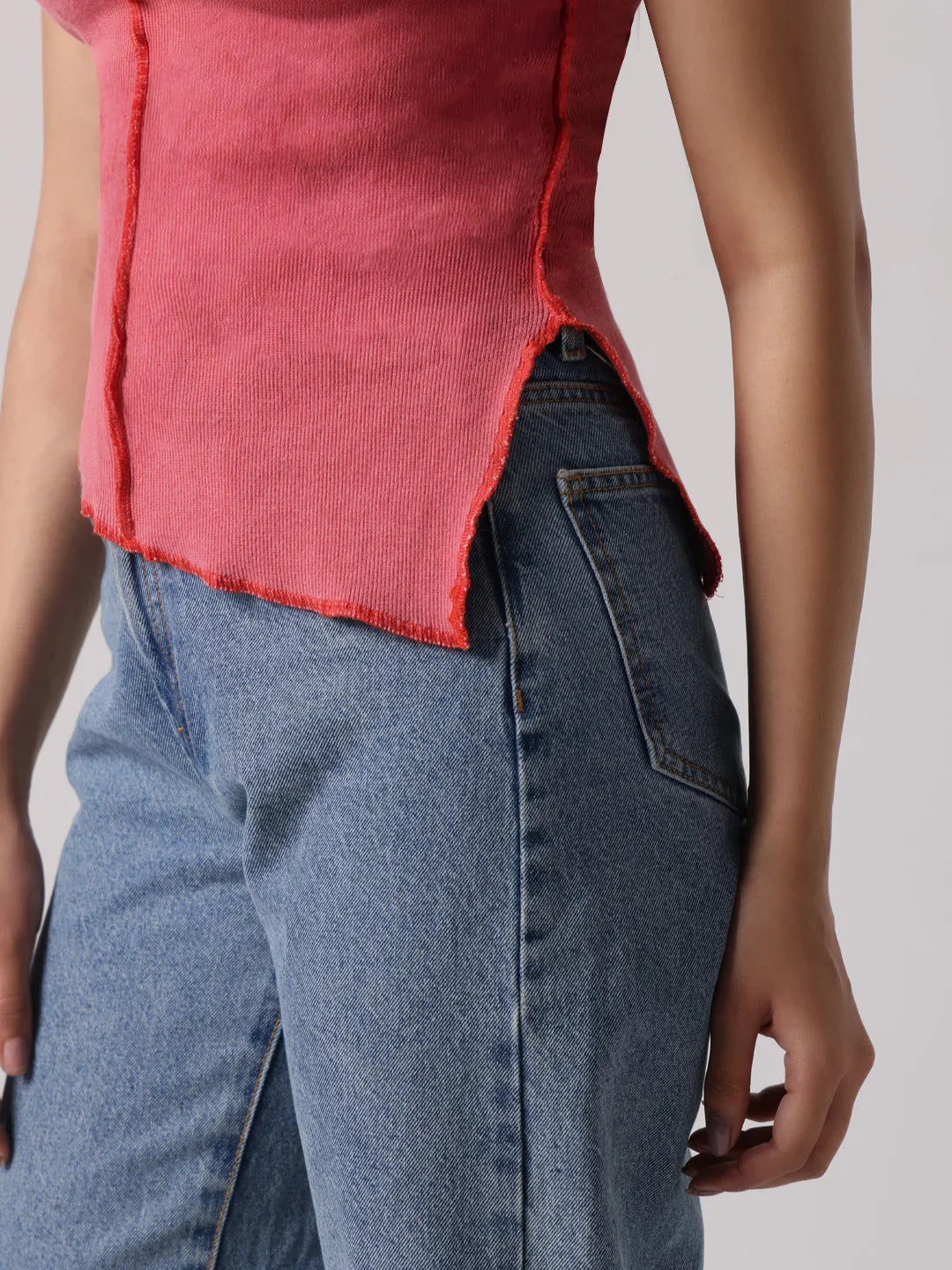 Rose-pink top hem with side slit and visible contrast exposed-stitch edge