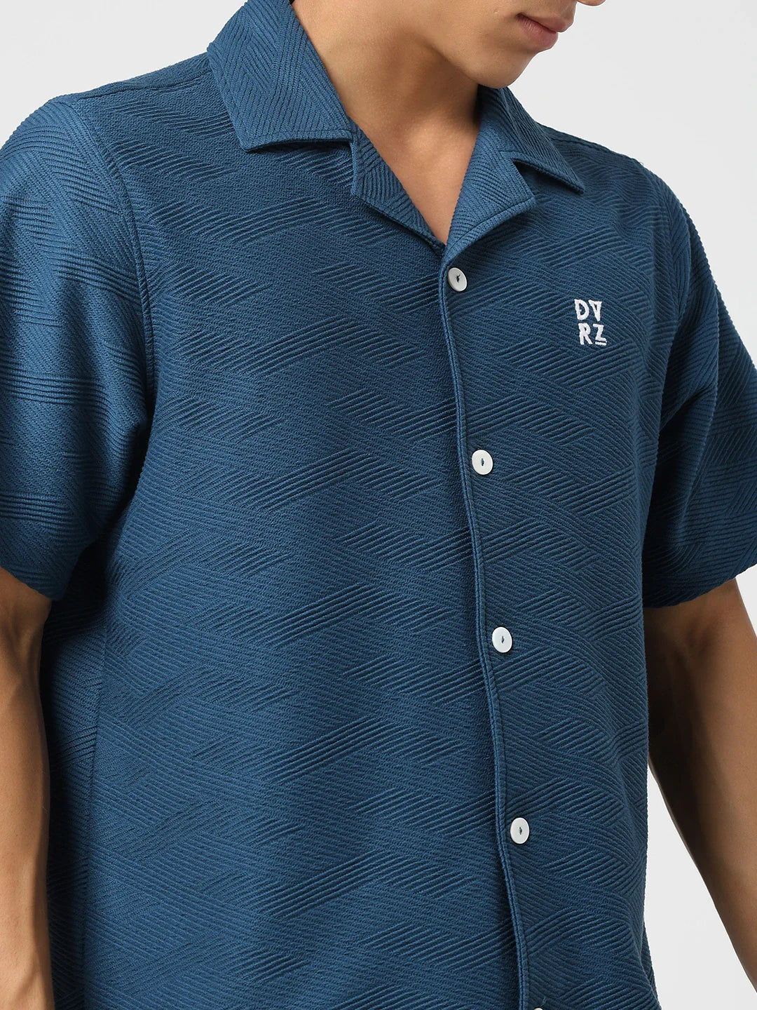 Blue textured bowling shirt close-up: pointed collar, button front, chest logo