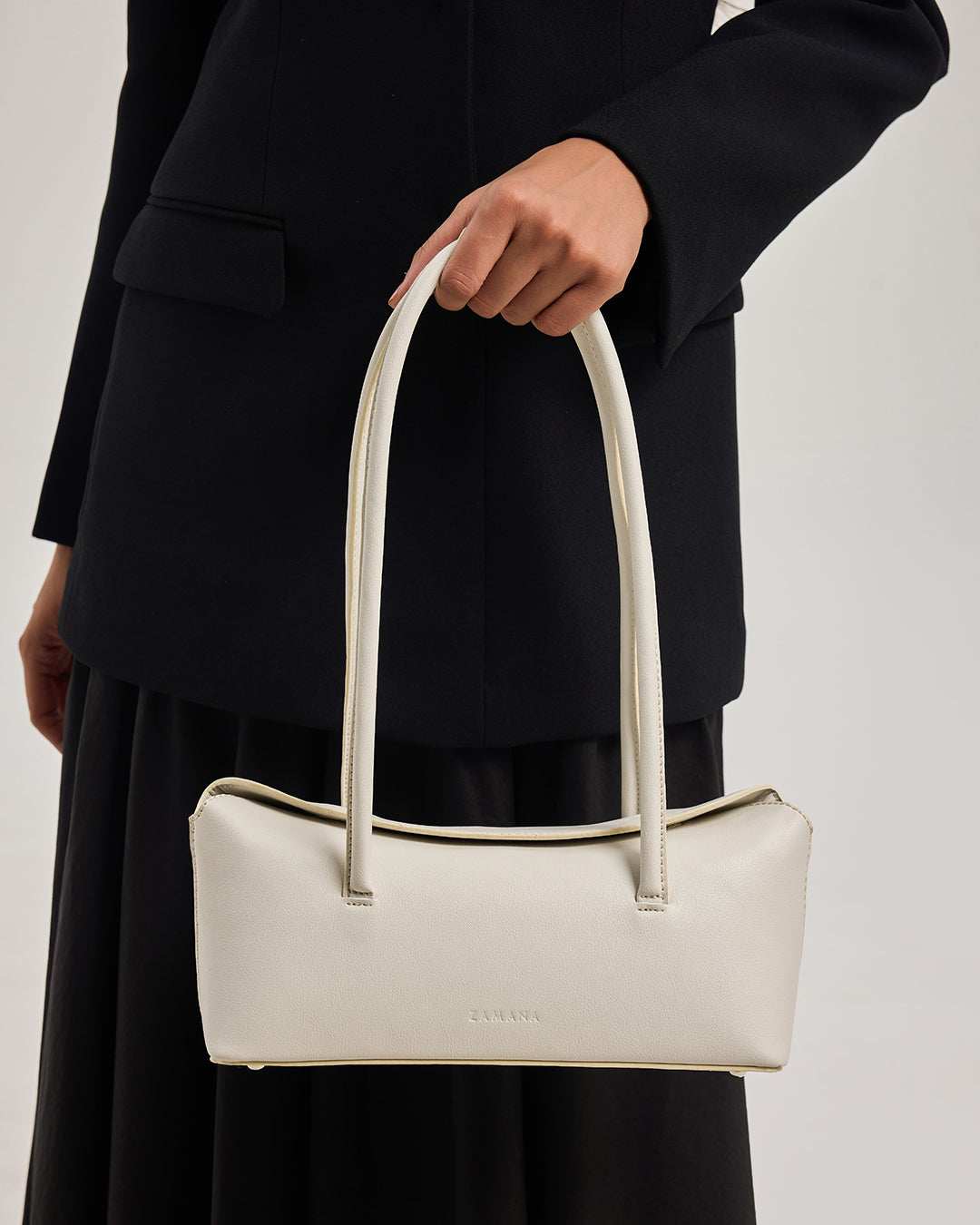 Cream tote bag with two top handles and small center logo