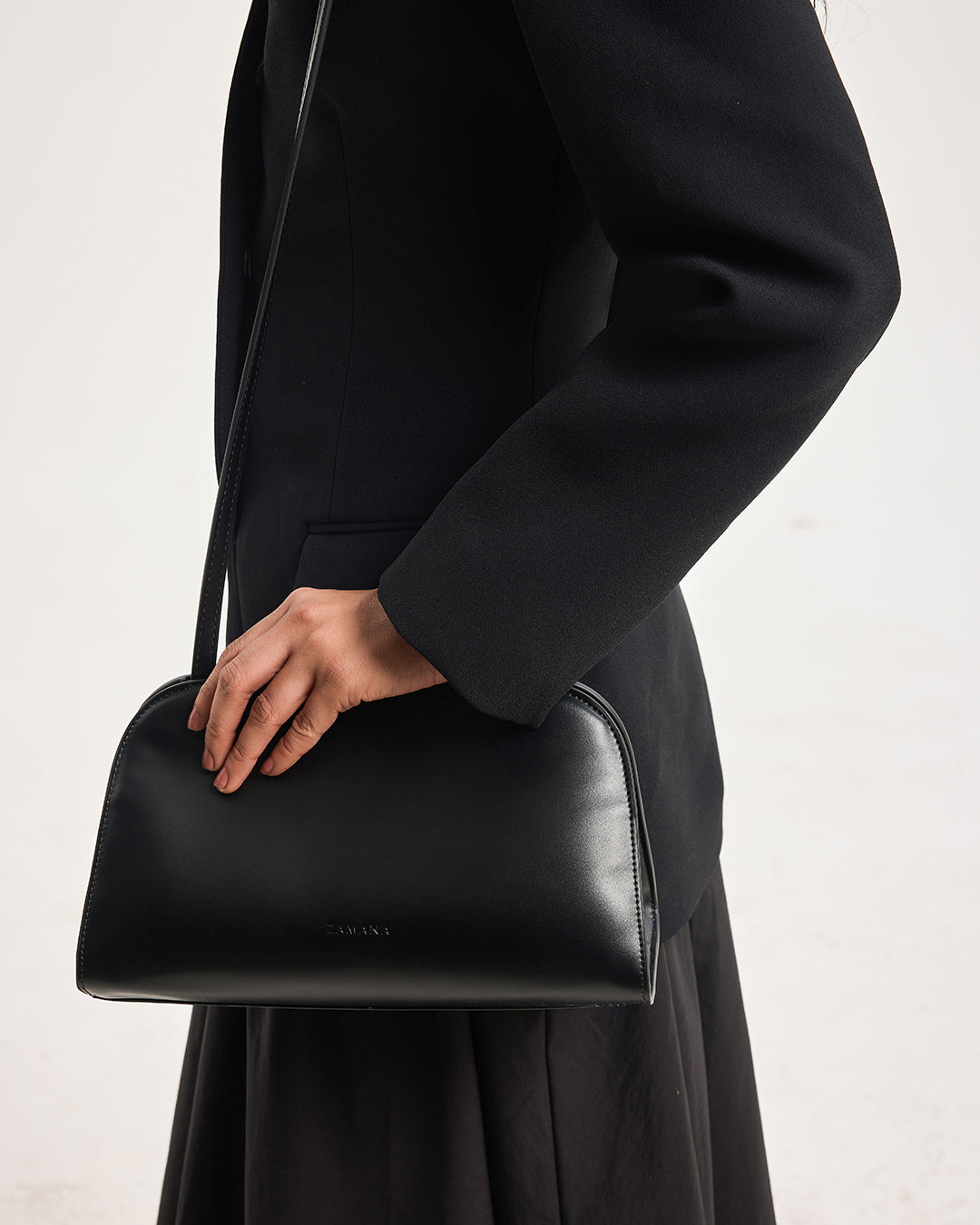 Black structured handbag with top handle and subtle logo