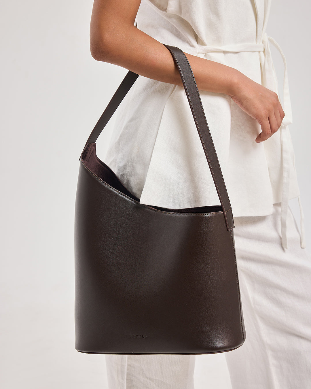 THE DECEMBER dark brown leather shoulder bag front view with curved handles