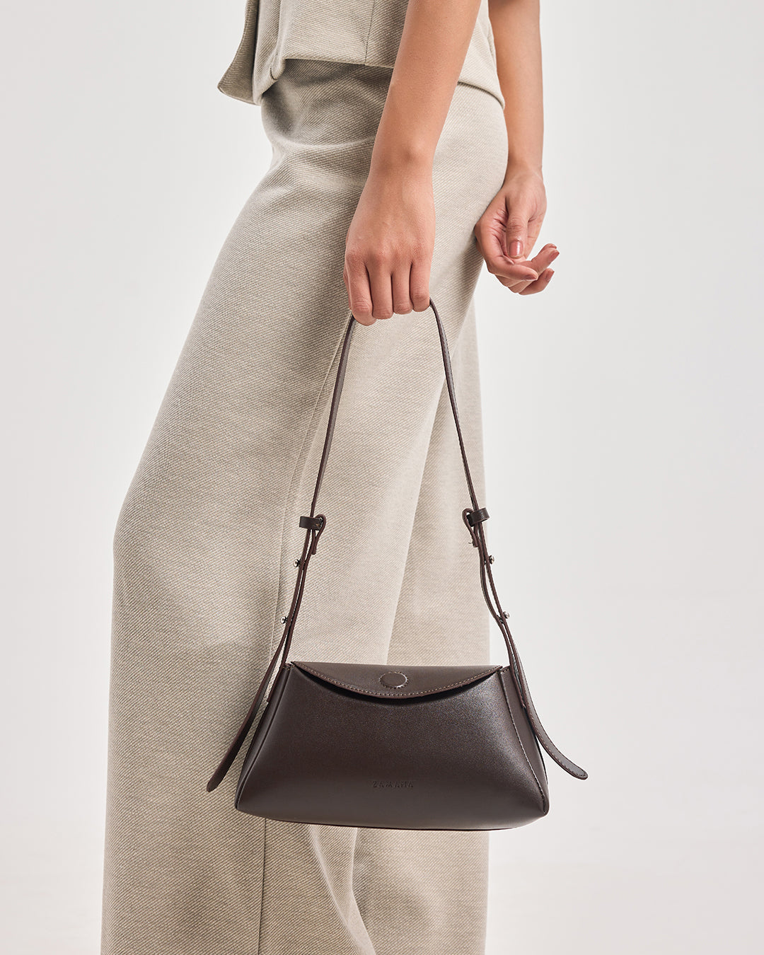Dark brown leather hobo shoulder bag worn across front with short handles