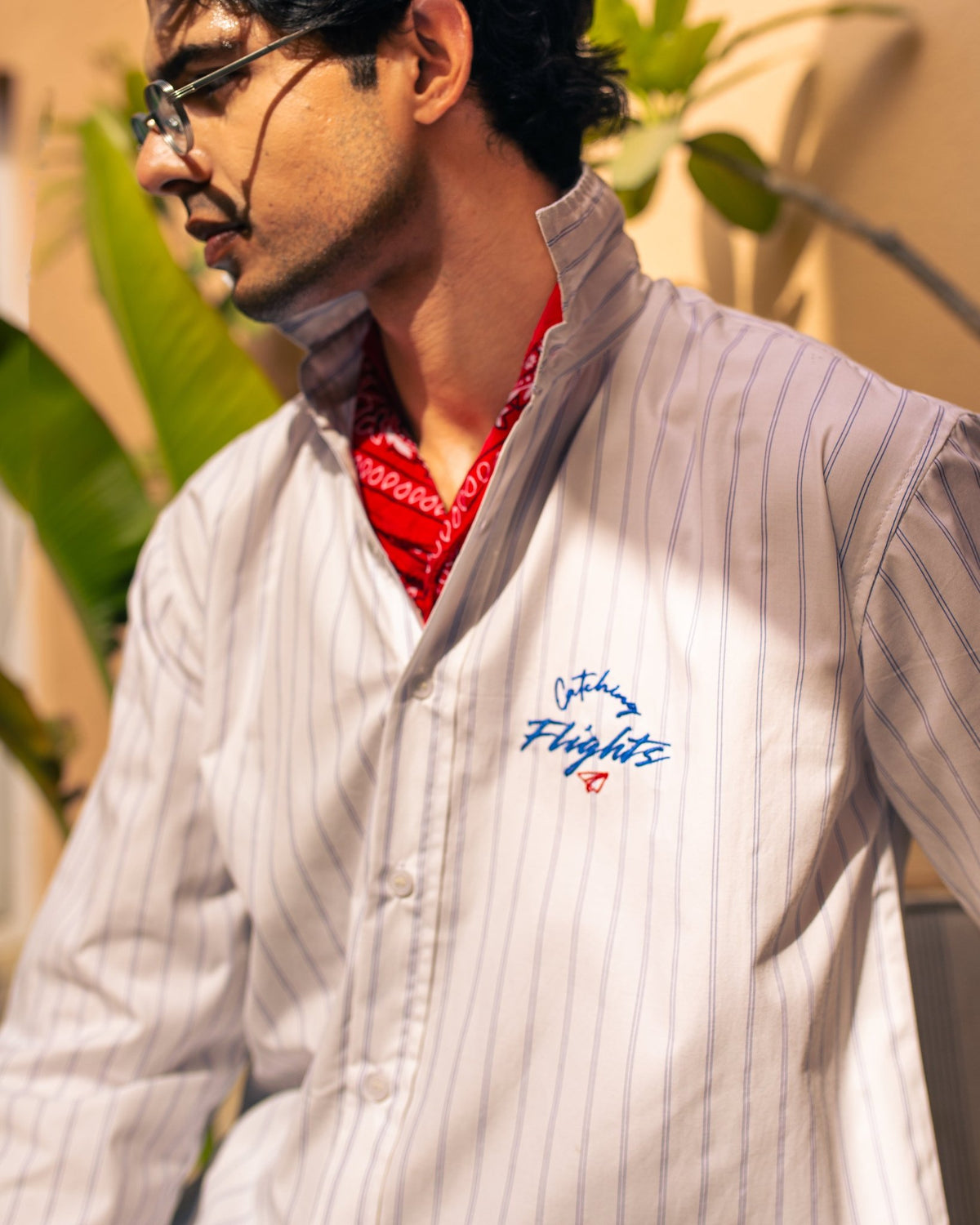 White pinstripe suiting shirt with blue vertical stripes, red inner collar, chest logo
