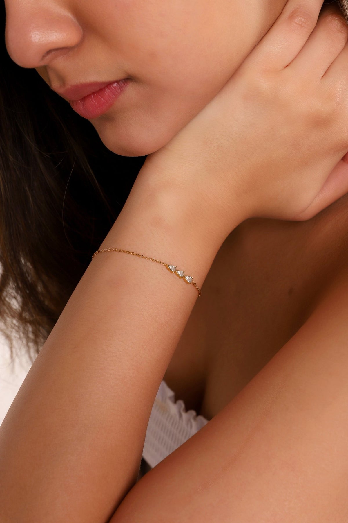 Gold-tone bracelet with small clear stones, close-up on wrist