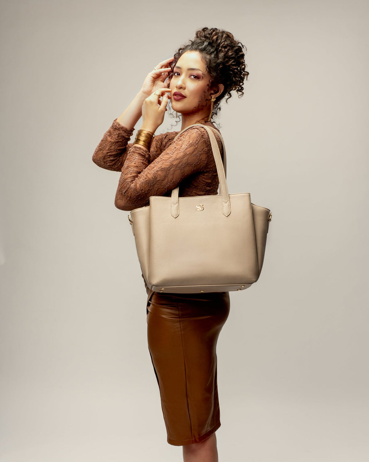 Almond cream tote bag carried on shoulder with gold-tone hardware