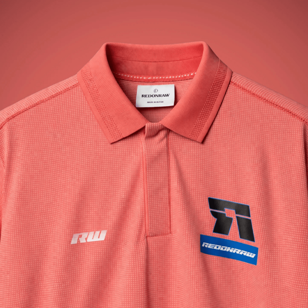 Coral polo shirt with collar, button placket, and chest logos including REDONRATHIV