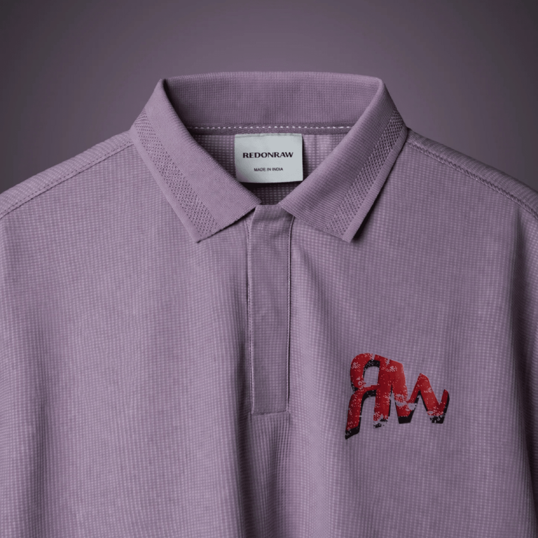 Lavender polo shirt with collar and button placket, “REDONRAW” label, and “AM” logo