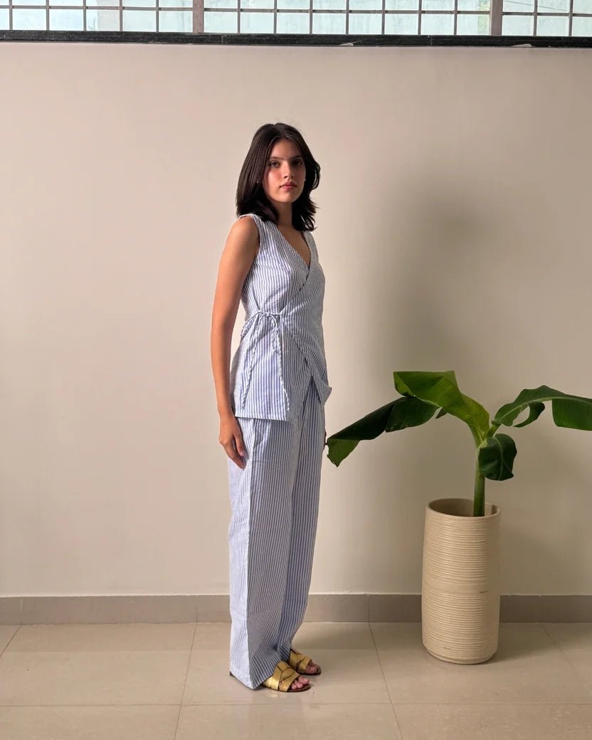 Light blue striped linen wrap top with side-tie detail and matching wide-leg trousers