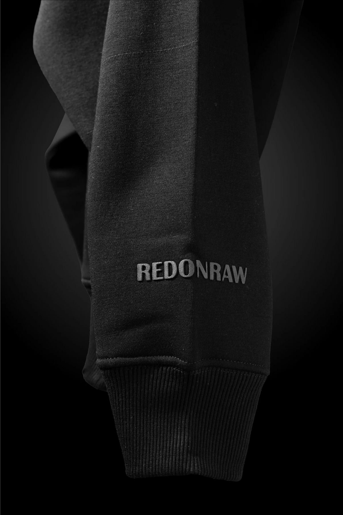 Charcoal black hoodie sleeve cuff with REDONRAW logo print