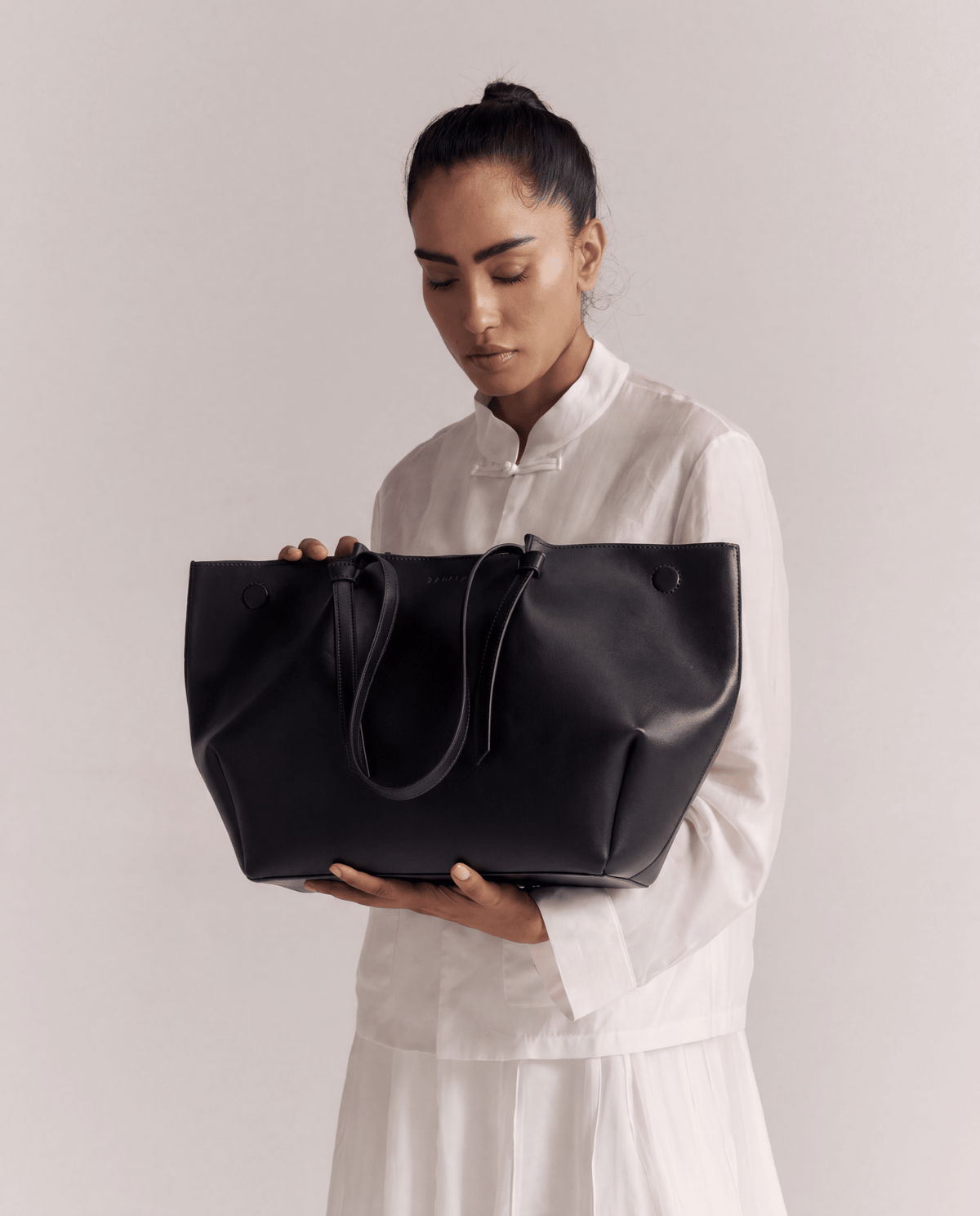 Large black tote bag with drawstring-like cord and wide open top