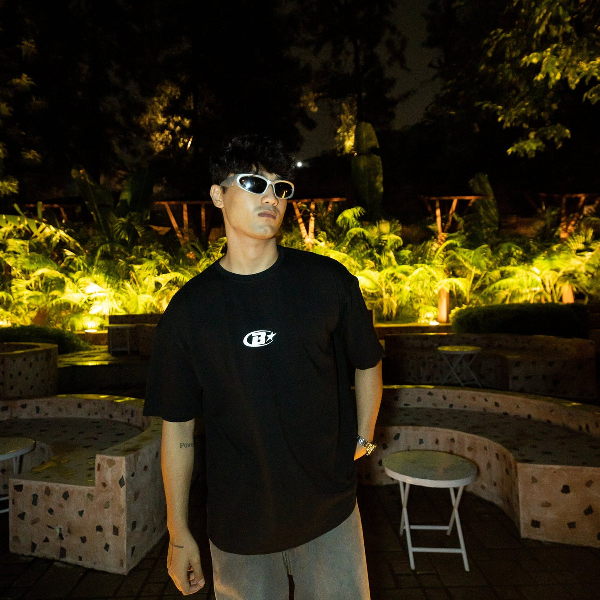 Black crewneck tee with small chest logo and round neckline