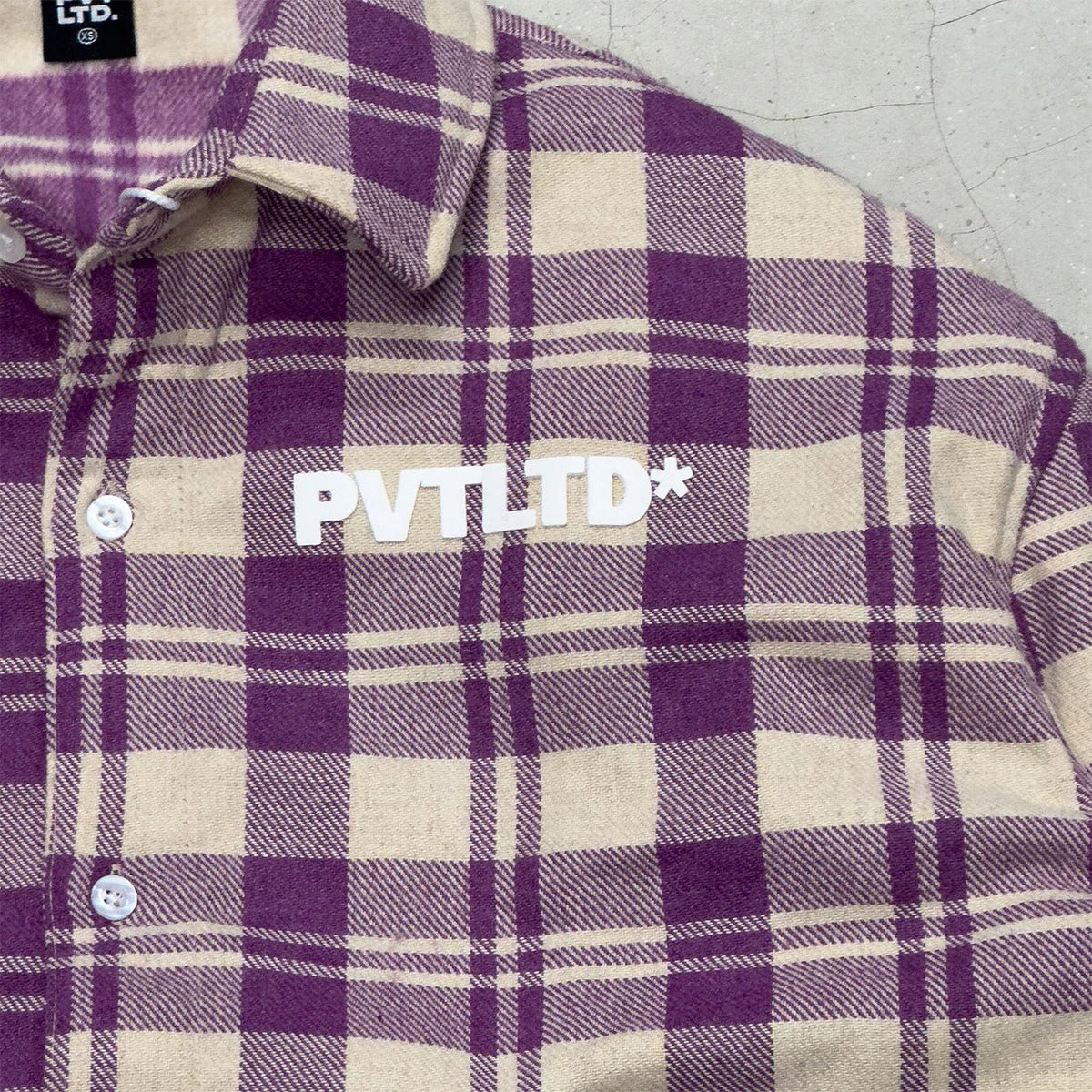 Plaid shirt logo PVTLTD* with button detail on the chest